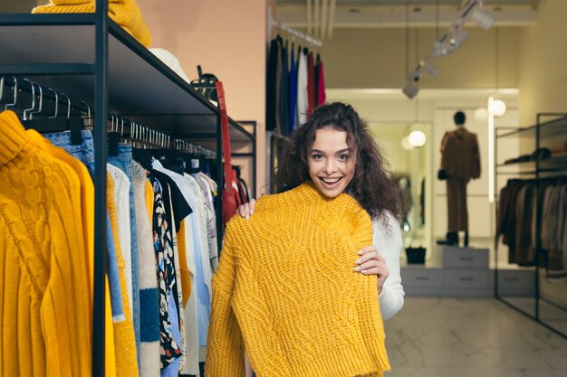 Mooi meisje koper, mooie stijlvolle kleding in een boetiek passen en kopen