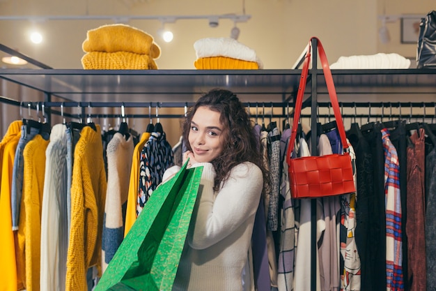 Mooi meisje koper, mooie stijlvolle kleding in een boetiek passen en kopen