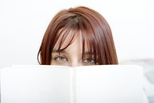 Foto mooi meisje leest een boek in haar bed