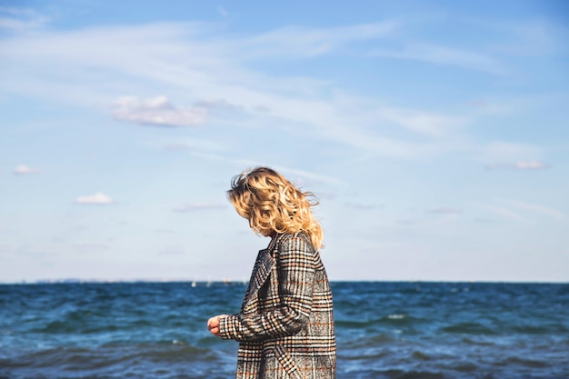 Foto mooi meisje loopt in de herfst en beoefent mindfulness aan zee.