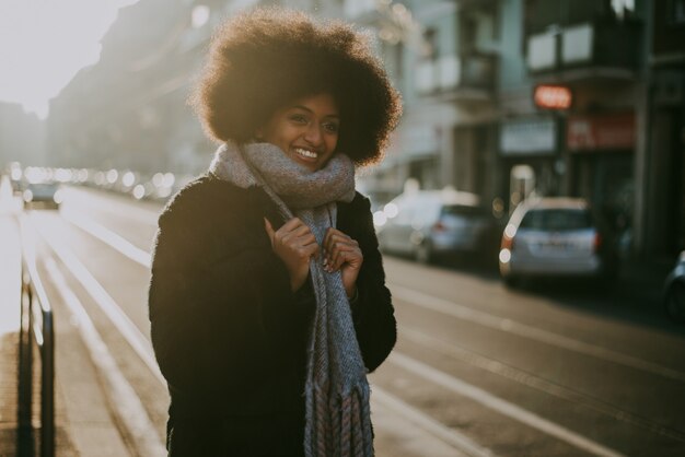 Mooi meisje met afro kapsel lopen op straat