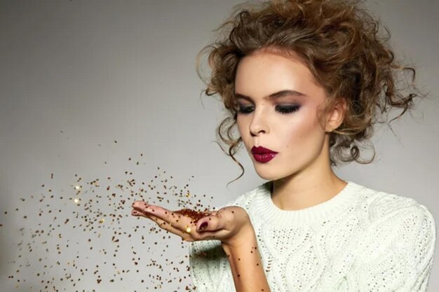 Mooi meisje met avondmake-up. Blow gold sequins.