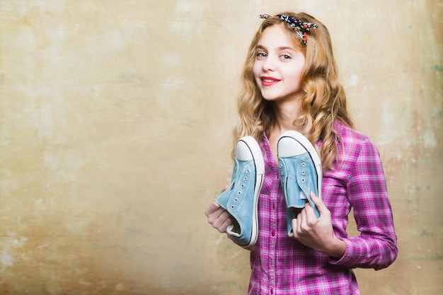 Foto mooi meisje met blauwe mode-sneakers in handen