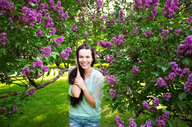 Mooi meisje met bloeiende bomen in het park. Voorjaar.