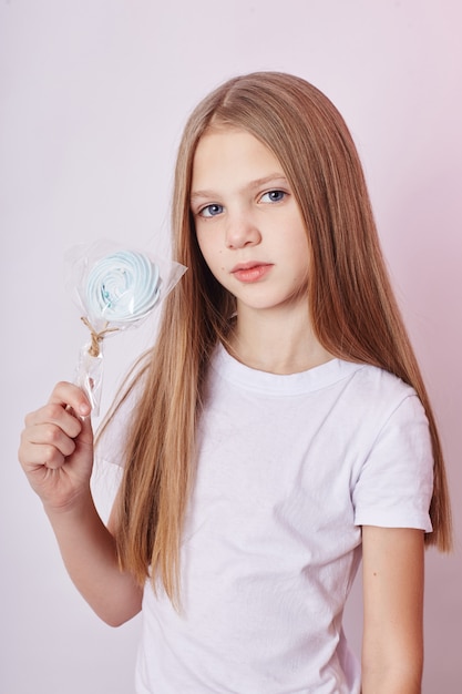 Mooi meisje met blond haar eet een lolly