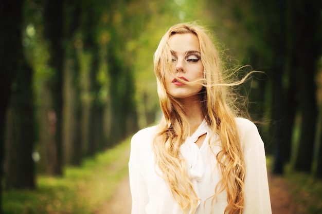 Mooi meisje met blond winderig haar. Herfst buitenshuis portret