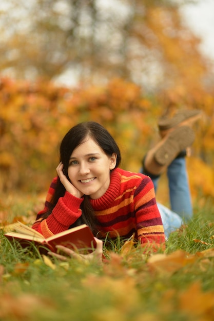 Mooi meisje met boek in het herfstpark