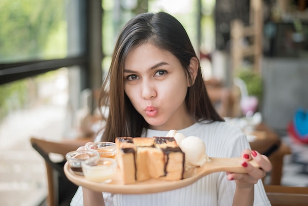 Mooi meisje met dessert in koffie winkel