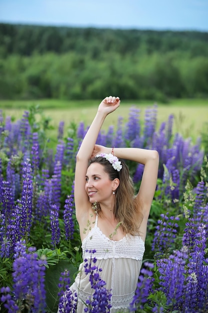 Mooi meisje met een boeket blauwe bloemen op de natuur in de zomer