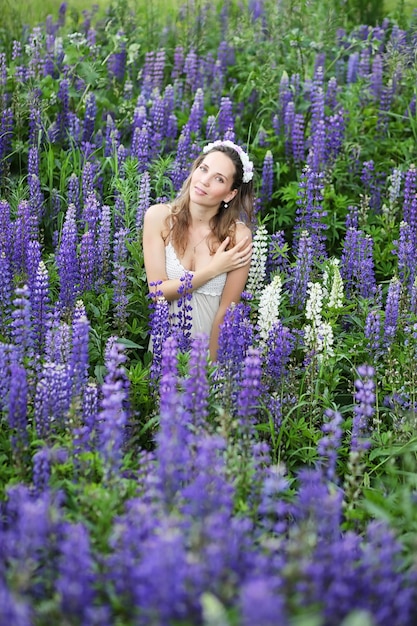 Mooi meisje met een boeket blauwe bloemen op de natuur in de zomer