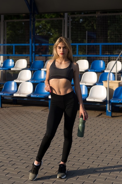 Mooi meisje met een sportief lichaam poseren in het stadion