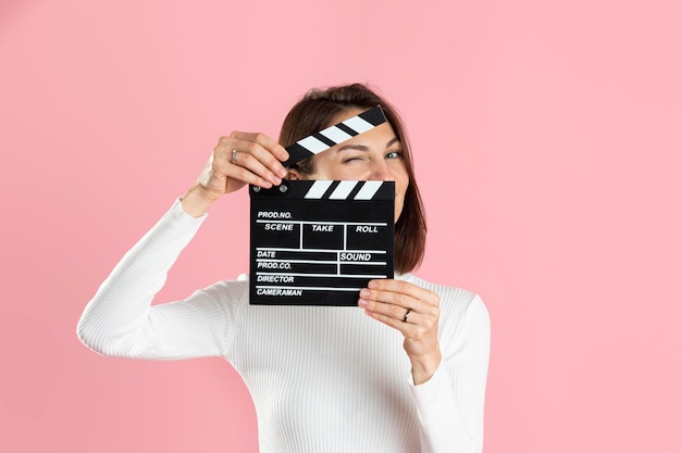 Mooi meisje met film Filmklapper op roze achtergrond