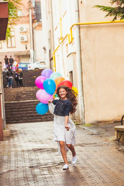 Mooi meisje met grote kleurrijke ballonnen wandelen in de oude stad