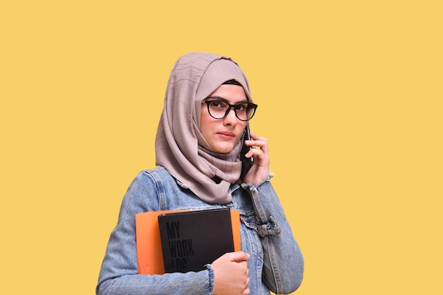 mooi meisje met hijab met boek en aangenaam telefoongesprek Indisch Pakistaans model