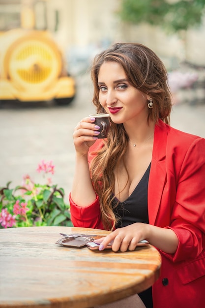 Mooi meisje met koffie in café buitenshuis.