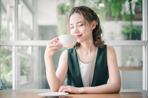 Mooi meisje met koffiekop in de ochtend.