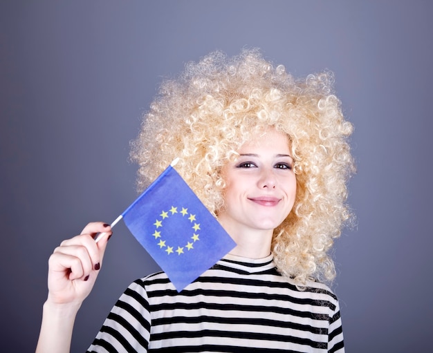 Foto mooi meisje met krullen tonen de vlag van de europese unie.