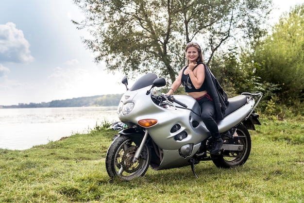 Mooi meisje met lang haar poseren op een motorfiets