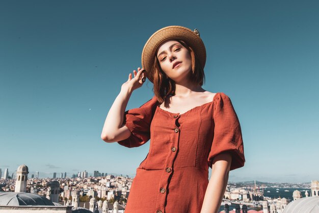 Mooi meisje met oranje gekleurde jurk poseren met Istanbul Scene