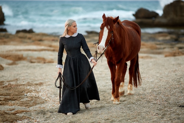 Mooi meisje met paard op zeekust