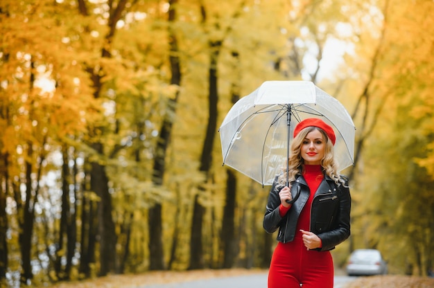 Mooi meisje met paraplu in herfst park.