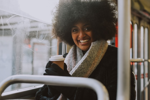 Mooi meisje met portretten van het afrokapsel in het openbaar vervoer
