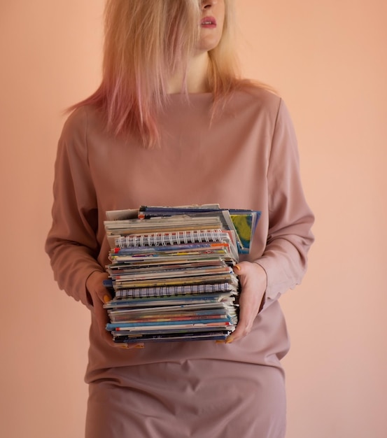 Mooi meisje met schriften in haar handen Portret met kopieerruimte lege plaats Portret van slim opgeleid meisje houdt veelkleurige papieren mappen vast