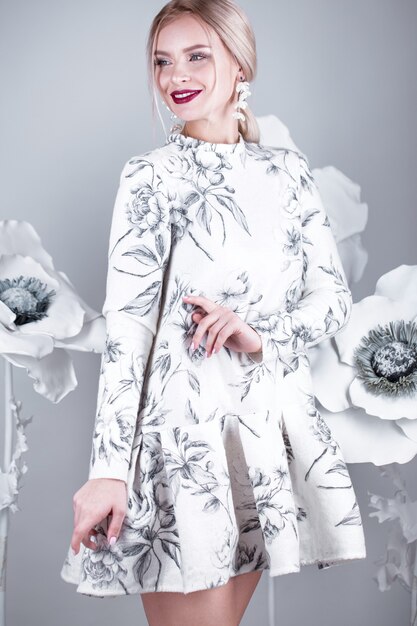 Mooi meisje met vintage make-up en kapsel in een warme winter wollen jurk. decoratie van bloemen. De schoonheid van het gezicht. Foto's gemaakt in studio