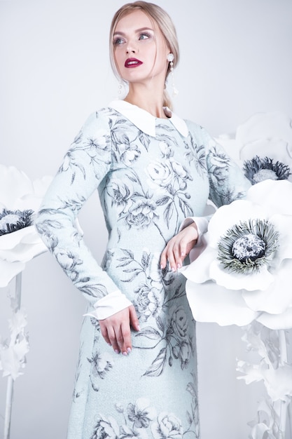 Mooi meisje met vintage make-up en kapsel in een warme winter wollen jurk. decoratie van bloemen. De schoonheid van het gezicht. Foto's gemaakt in studio