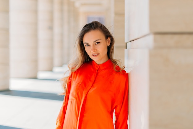 Mooi meisje model poseren voor de camera in de stad in de schaduw van het gebouw