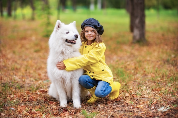 Mooi meisje op een wandeling met een mooie hond in een park buiten