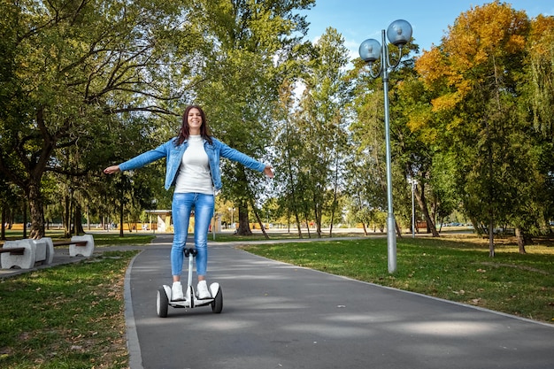 Mooi meisje op een witte hoverboard in het park