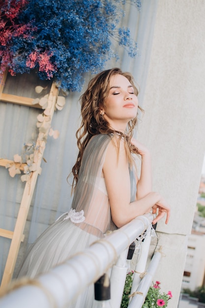 Mooi meisje op het balkon in een grijze jurk Reclame voor cosmetica en verzorgingsproducten