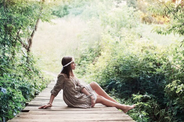 Mooi meisje op oude houten brdge in het bos