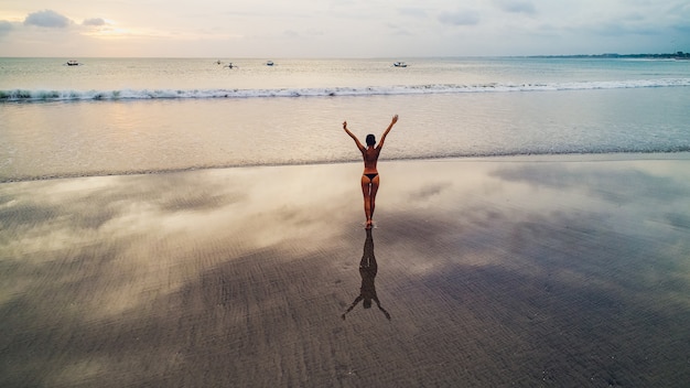 Mooi meisje op zonsondergang achtergrond op zandstrand