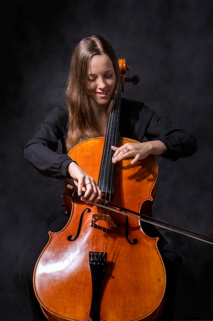 Mooi meisje professionele cellist die antieke cello speelt