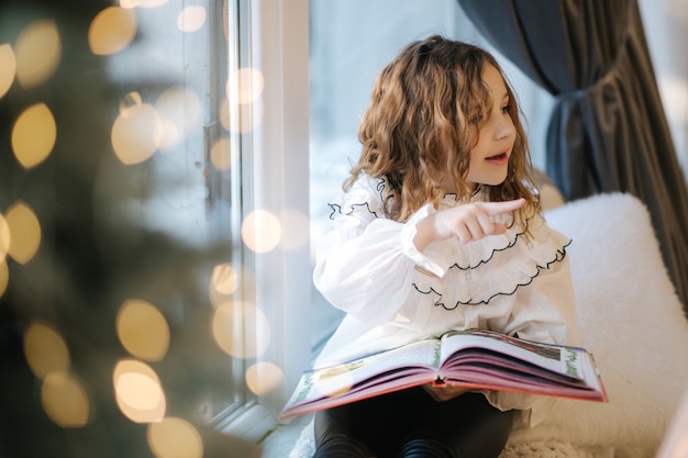 Mooi meisje readind boek tijdens kerstvakantie