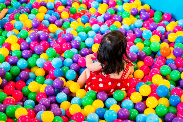 Mooi meisje spelen met plastic ballen.