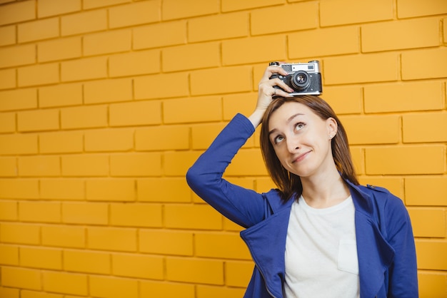 Mooi meisje tegen gele bakstenen muur