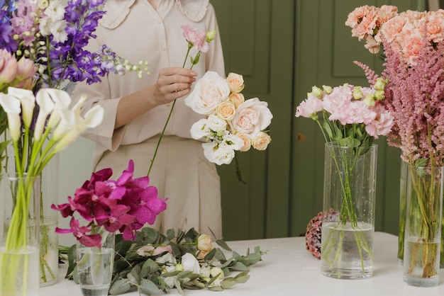 Mooi meisje verzamelt een boeket bloemen in een bloemenwinkel