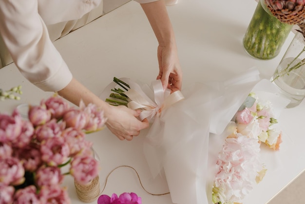 Mooi meisje verzamelt een boeket bloemen in een bloemenwinkel