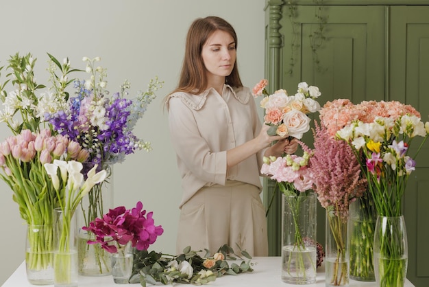 Mooi meisje verzamelt een boeket bloemen in een bloemenwinkel