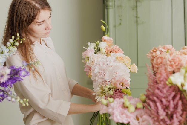 Mooi meisje verzamelt een boeket bloemen in een bloemenwinkel