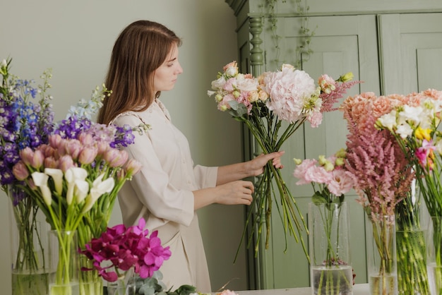 Mooi meisje verzamelt een boeket bloemen in een bloemenwinkel