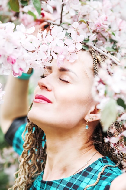 Mooi meisje wandelen Mooie vrouw over natuurlijke lente bloesem achtergrond