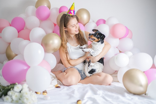Mooi meisje werd wakker omringd door ballonnen op de dag van de verjaardag met haar hond