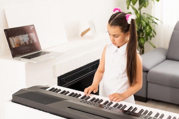 mooi meisje zingt tijdens het spelen op een elektronische piano.