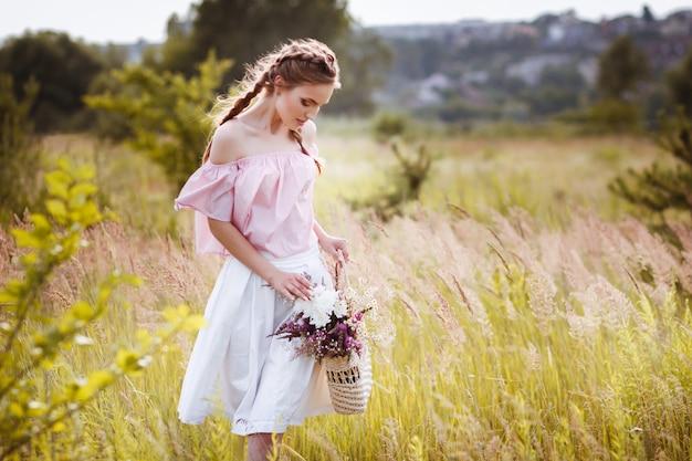 mooi model in een zomer veld bij zonsondergang