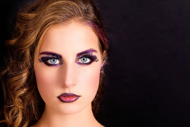 Mooi model met fashion make-up en kapsel op een zwarte achtergrond