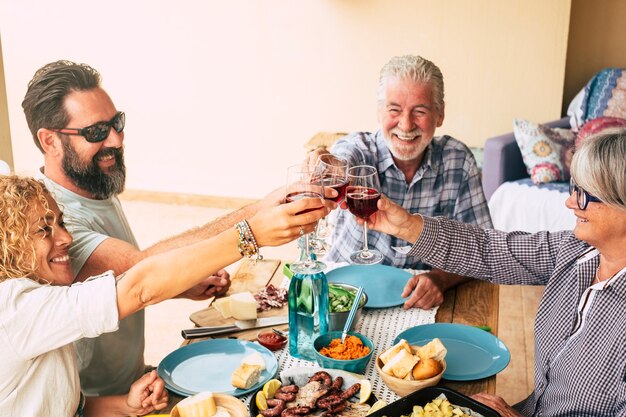 Mooi moment van gezinslevensstijl thuis eten en drinken van eten of drinken thuis op tafel - man met zonnebril die groenten tovert - tafel vol eten en salade buiten